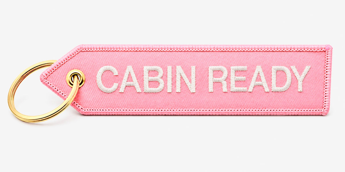 Rosa „Cabin Ready“ Schlüsselanhänger mit weißer Stickerei und goldfarbenem Ring
